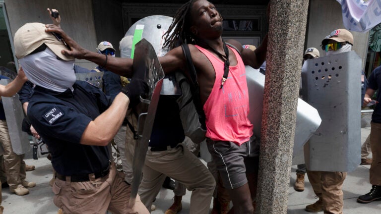 Charles Murrell fends off a marcher from a group bearing insignias of the white supremacist group Patriot Front in Boston.